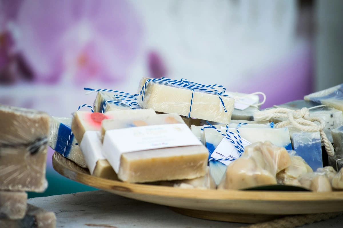 A craft fair table stocked with bars of handmade soap in a range of varieties