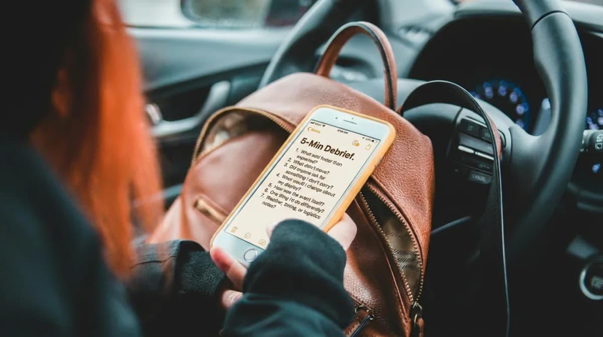 A vendor sitting in their car after a craft fair, reviewing a 5-minute debrief checklist on their phone before driving home
