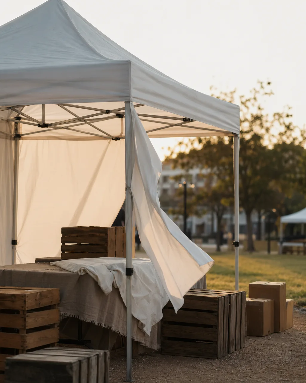 Windy outdoor market morning, tent canopy flapping in early light.